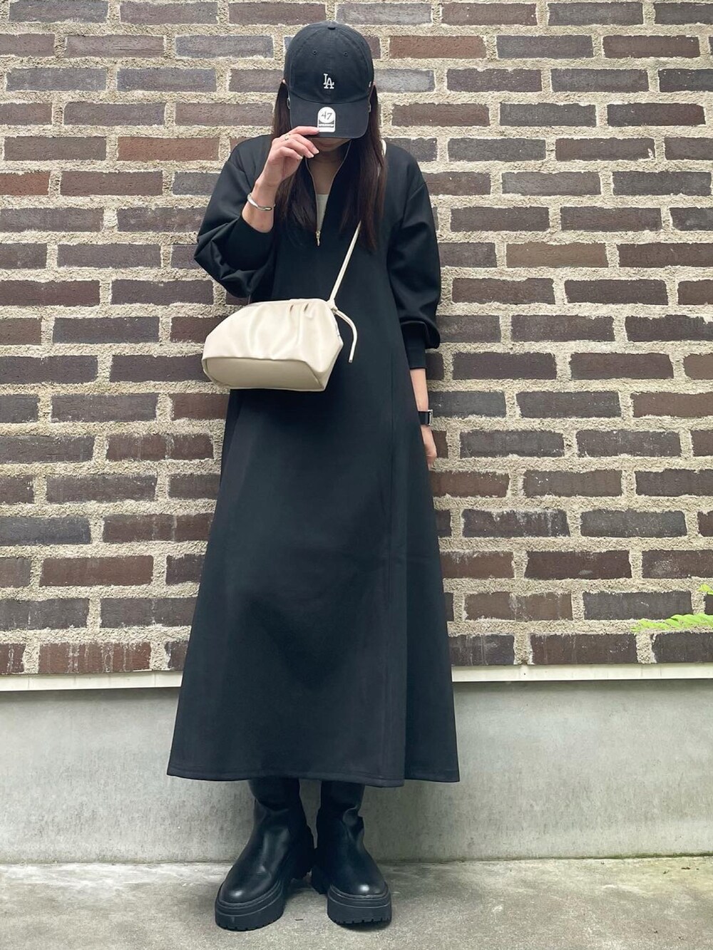 ブラック系のワンピース、ブラック系のキャップを着用したレディースの秋コーディネートの3枚目の写真