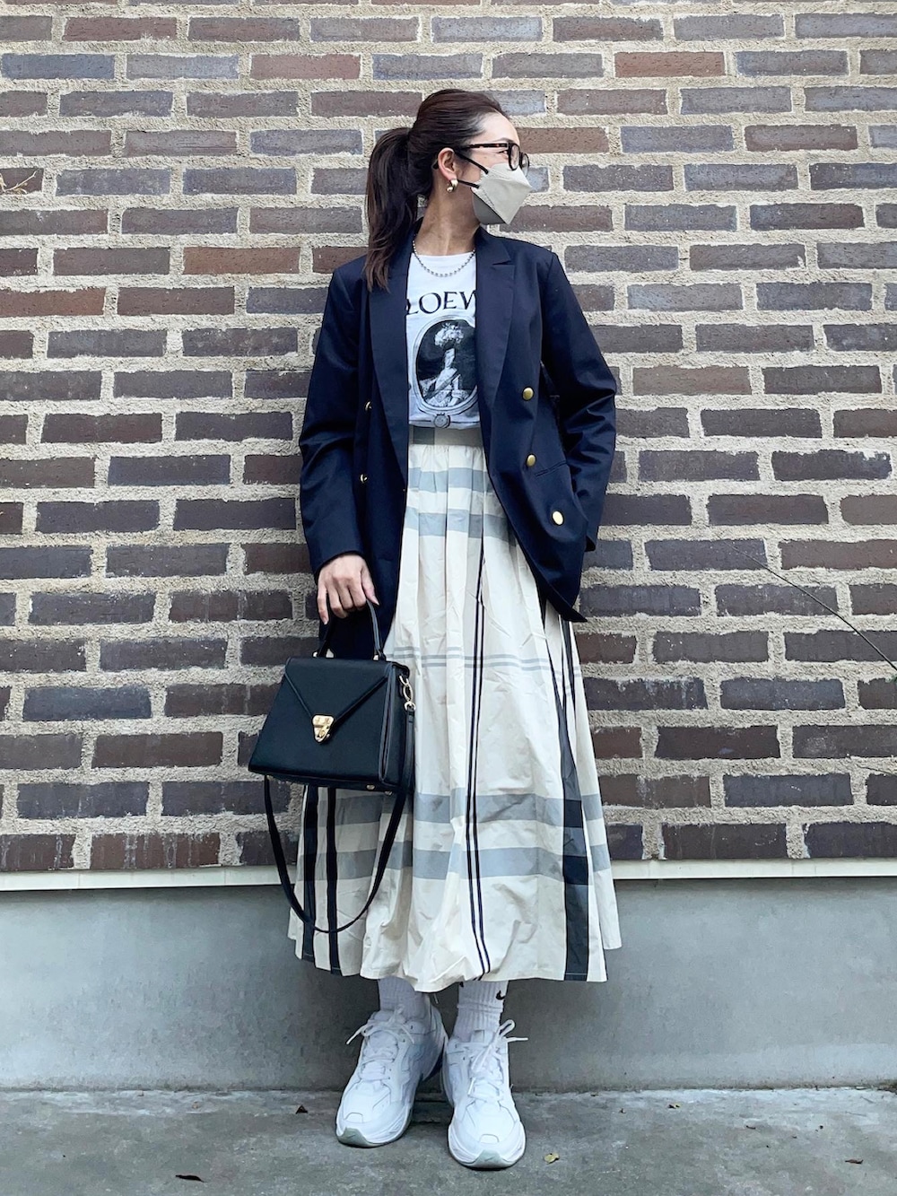 ホワイト系のスカート、ホワイト系のスニーカー、ブルー系のテーラードジャケットを着用したレディースの春コーディネートの2枚目の写真