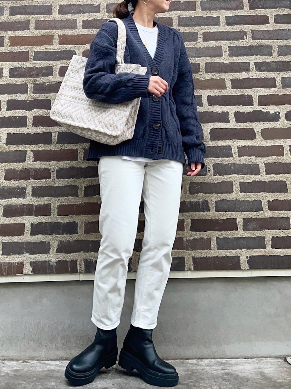 ブルー系のカーディガン/ボレロ、ホワイト系のデニムパンツ、ブラック系のブーツを着用したレディースの秋コーディネートの3枚目の写真