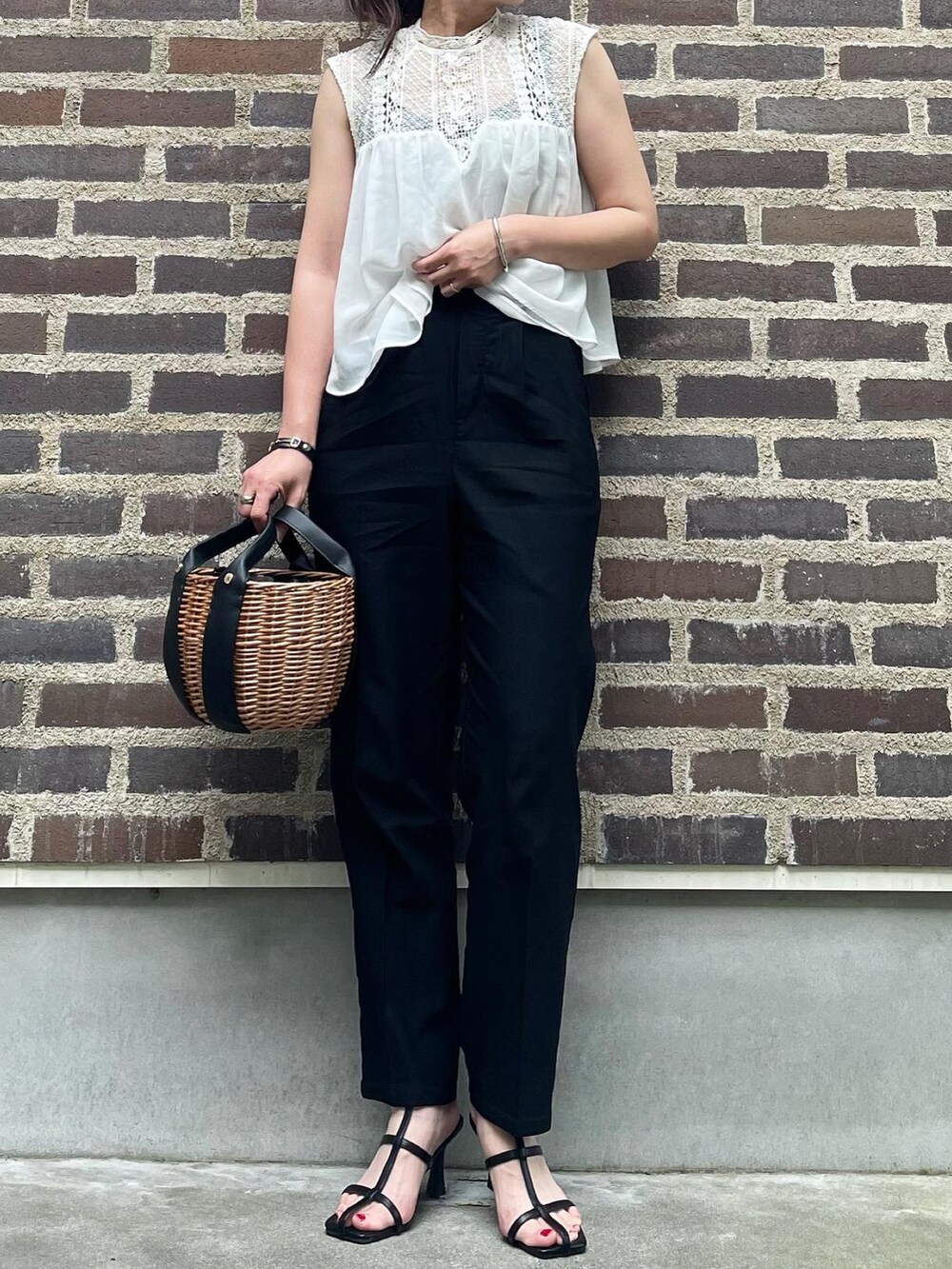 ブラック系のスラックス、ブラック系のサンダルを着用したレディースの夏コーディネートの4枚目の写真