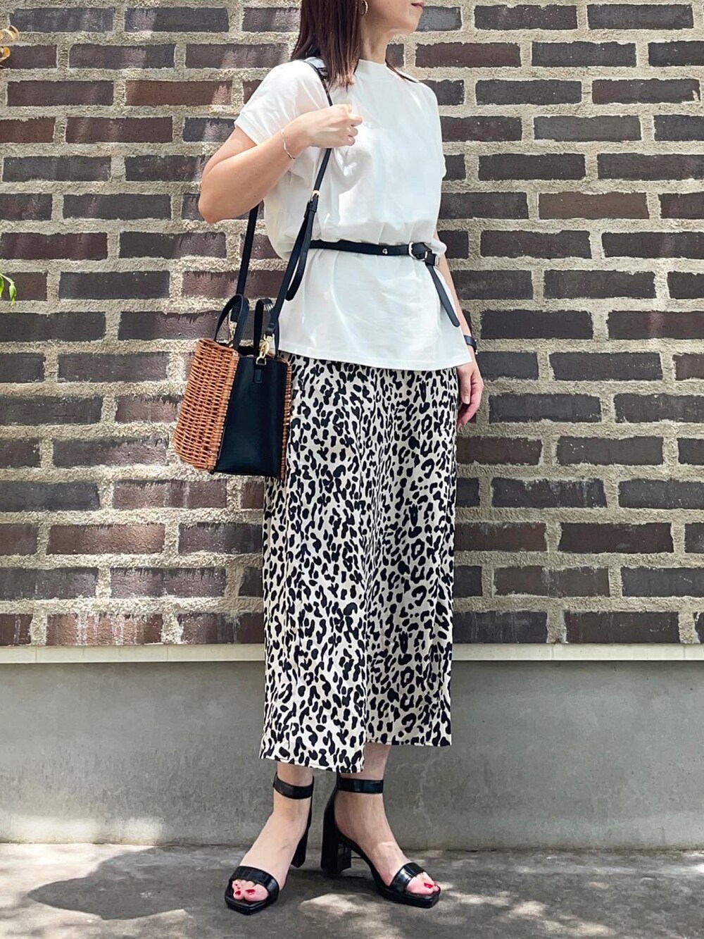 ホワイト系のTシャツ/カットソー、ベージュ系のスカート、ブラック系のサンダルを着用したレディースの夏コーディネートの3枚目の写真