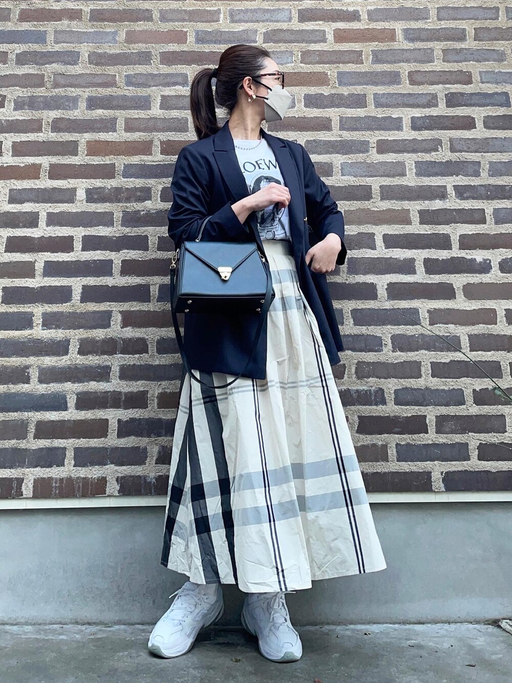 ホワイト系のスカート、ホワイト系のスニーカー、ブルー系のテーラードジャケットを着用したレディースの春コーディネートの4枚目の写真