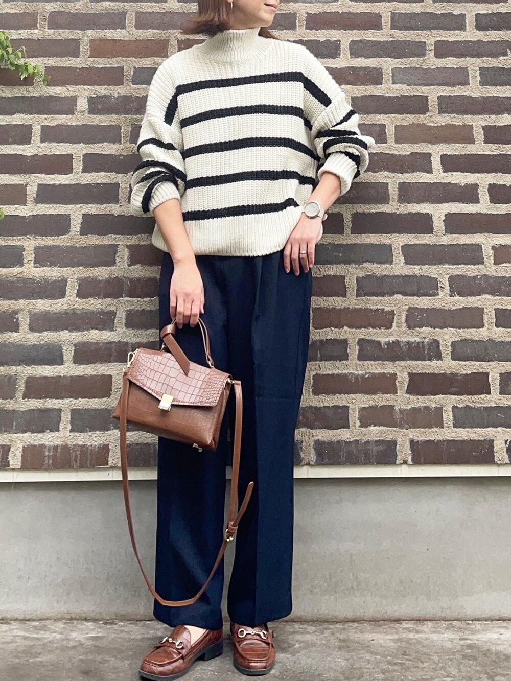 ブラウン系のショルダーバッグ、ブラウン系のローファー、その他のニット/セーターを着用したレディースの秋コーディネートの2枚目の写真