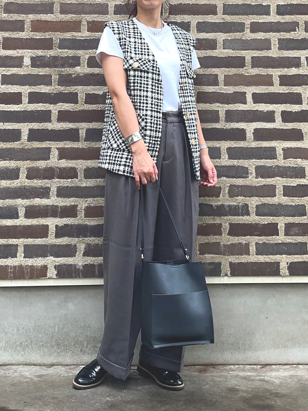 グレー系のスラックス、その他のベスト、ブラック系のローファーを着用したレディースの秋コーディネートの2枚目の写真