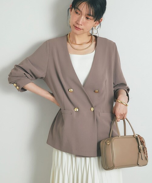 un dix cors(アンディコール)の「《接触冷感・速乾・セットアップ可》ハイストレッチカルゼワッシャー金釦ジャケット(ノーカラージャケット・レディース・モカ/ネイビー・F)」の1枚目の写真